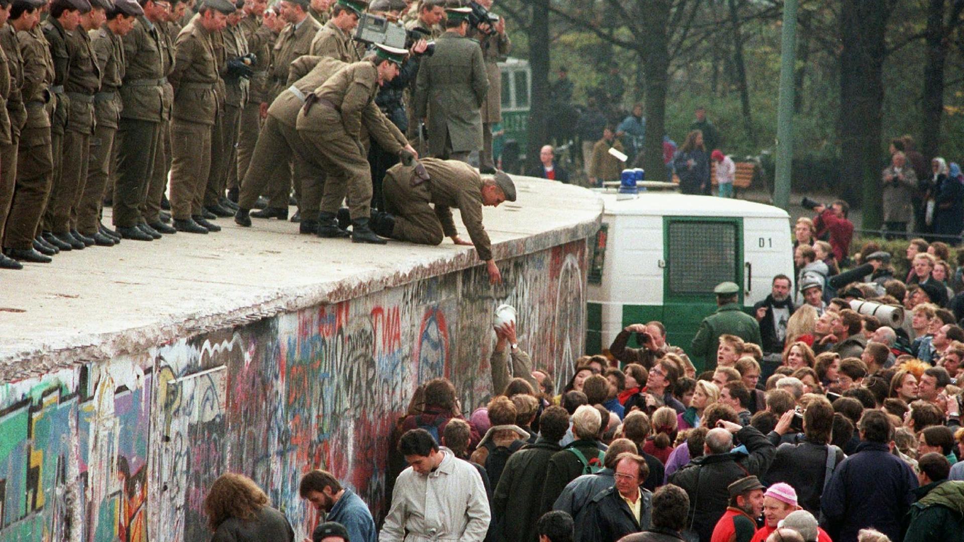 Demonstranten und Grenzpolizisten an der Mauer
