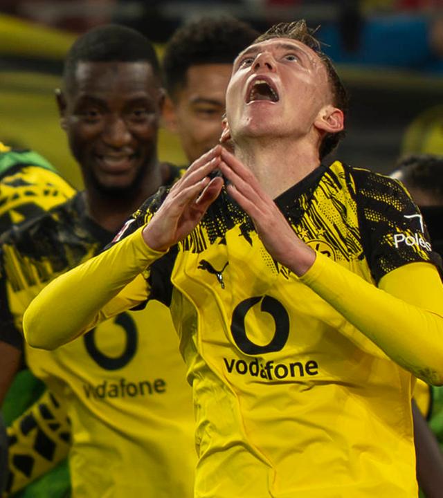 Maximilian Beier (Borussia Dortmund) schaut nach oben, während hinter ihm über den Sieg gegen Köln gejubelt wird.