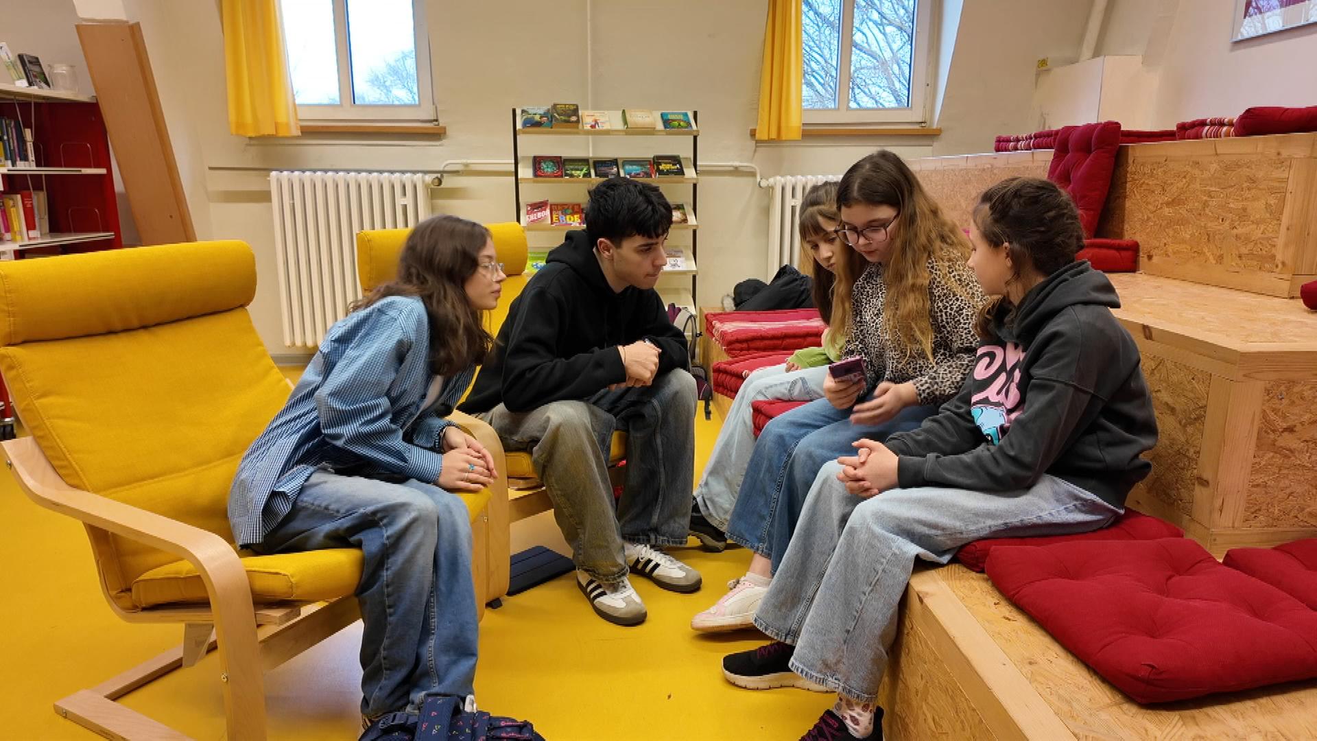 Schüler sitzen zusammen und sprechen miteinander