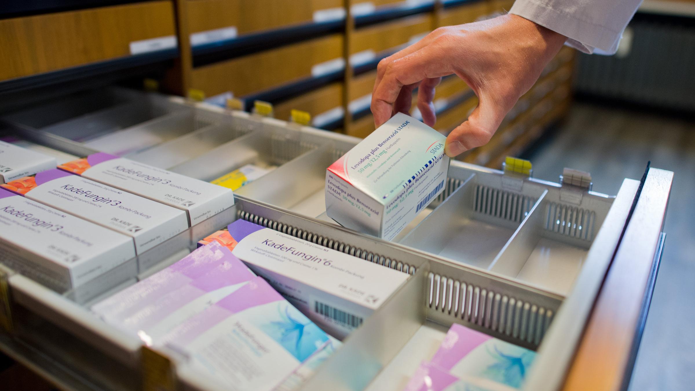 Ein Apotheker nimmt am 19.10.2016 ein verschreibungspflichtiges Medikament zur Behandlung der Parkinson-Erkrankung aus einer Schublade in einer Apotheke in Hannover (Niedersachsen) (gestellte Szene). 