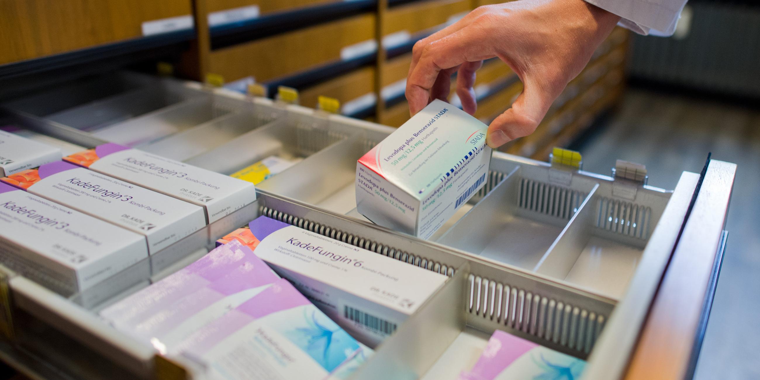 Ein Apotheker nimmt am 19.10.2016 ein verschreibungspflichtiges Medikament zur Behandlung der Parkinson-Erkrankung aus einer Schublade in einer Apotheke in Hannover (Niedersachsen) (gestellte Szene). 