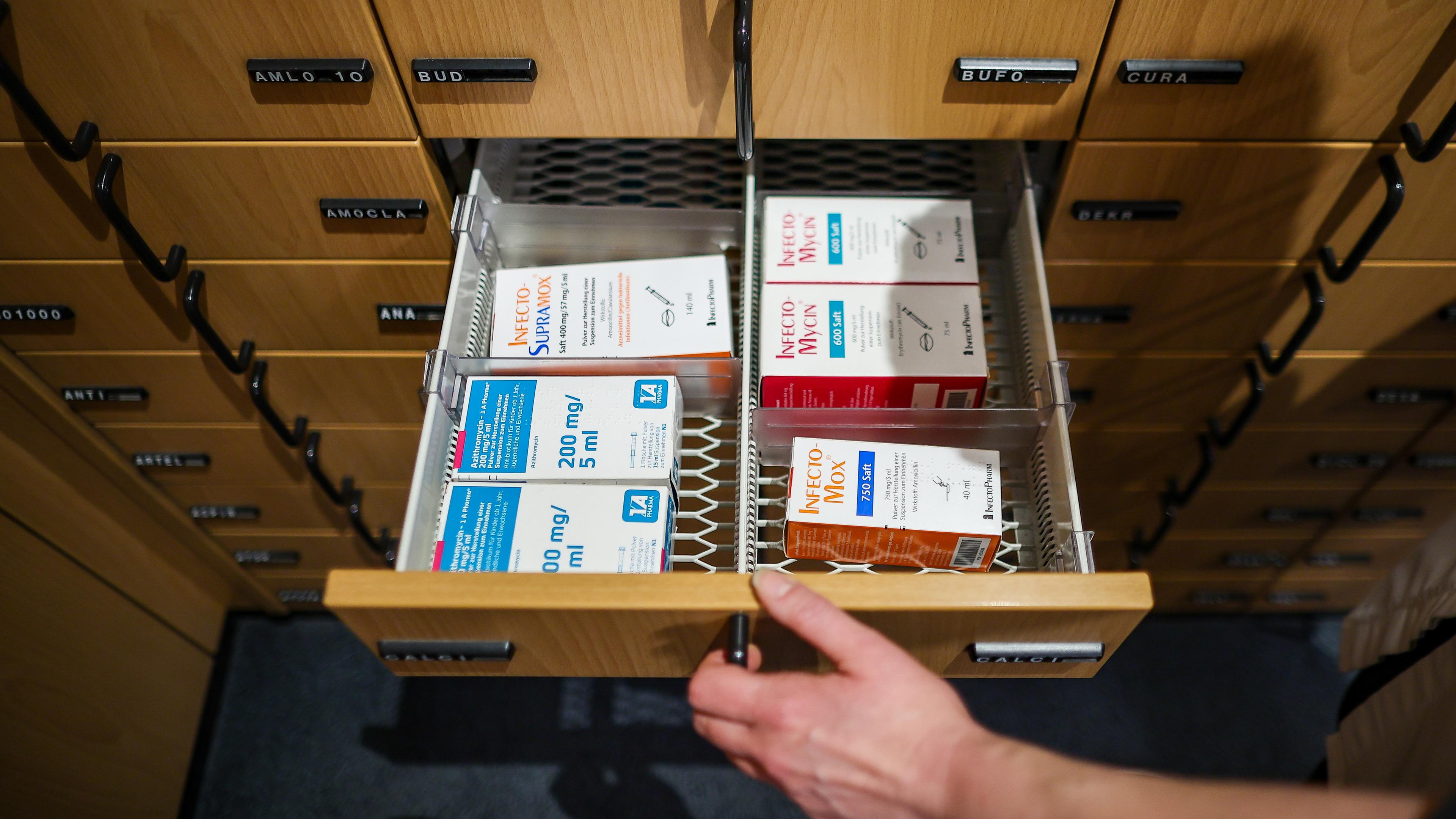 Eine Apothekerin öffnet ein Schubfach mit Antibiotikasäften für Kinder, aufgenommen am 03.05.2023