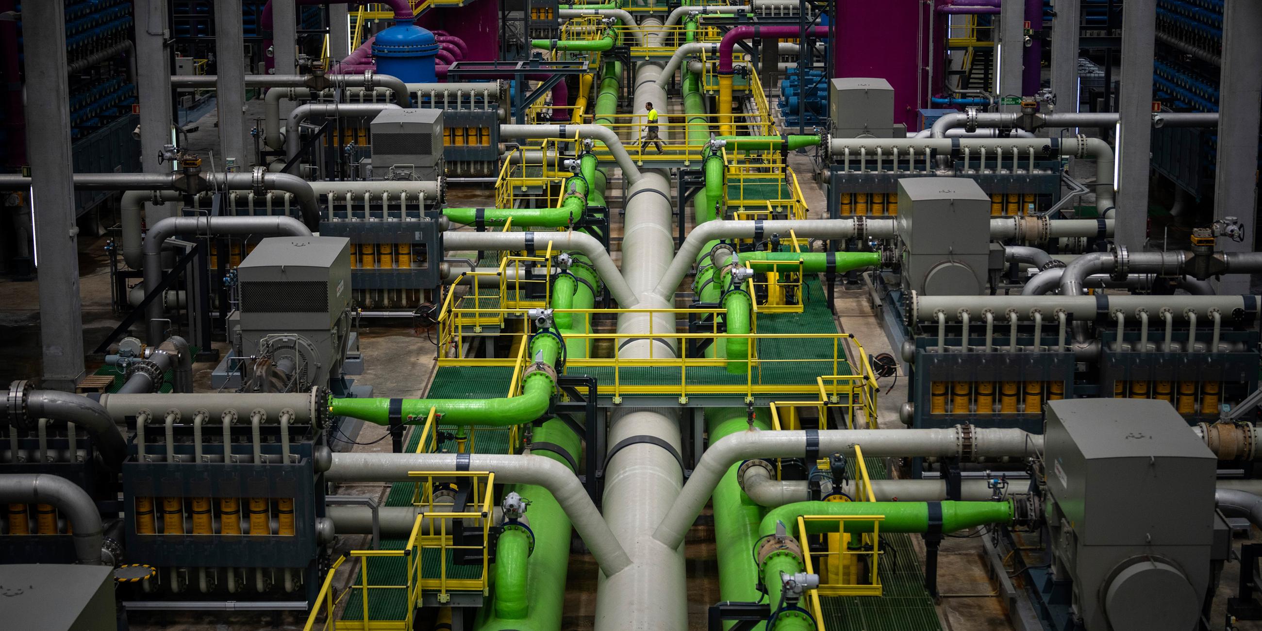 Ein Arbeiter geht über eine Pipeline, in Europas größter Entsalzungsanlage für Trinkwasser in Barcelona, Spanien.