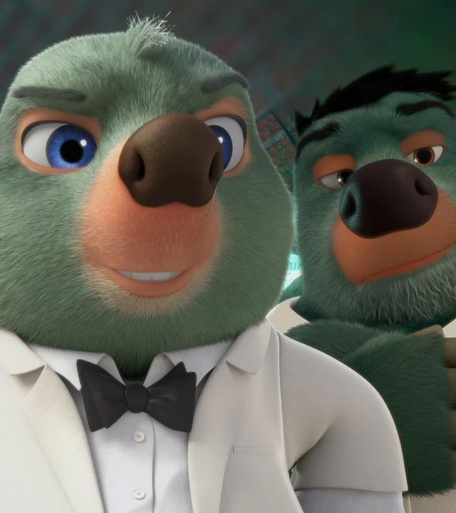 Moley trägt ein weißes Hemd, Sakko und eine schwarze Fliege, ganz so wie James Bond. Er blickt mit selbstbewusster, cooler Miene in die Kamera.