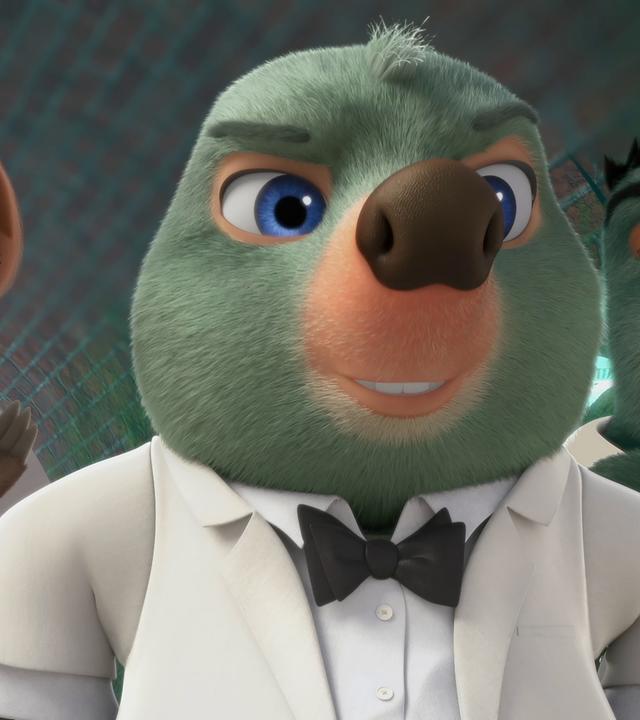 Moley trägt ein weißes Hemd, Sakko und eine schwarze Fliege, ganz so wie James Bond. Er blickt mit selbstbewusster, cooler Miene in die Kamera.