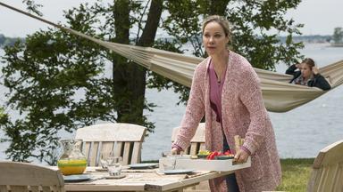 Die New Yorker Verlegerin Ann Withers (Ann-Kathrin Kramer) deckt im Garten ihres Sommerhauses am Meer den Frühstückstisch ab