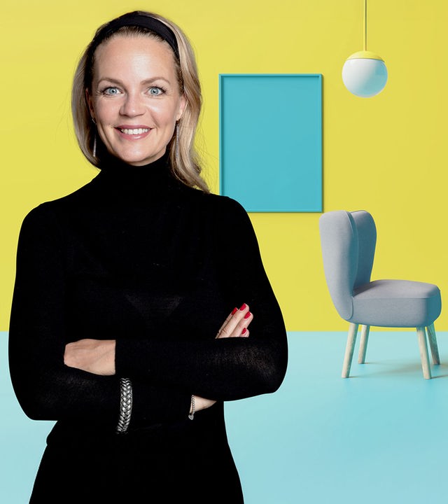Eva Brenner vor gelb-blauem Hintergrund, rechts von ihr die Animation eines Wohnbereichs mit Stühlen, Bildern und Lampen.