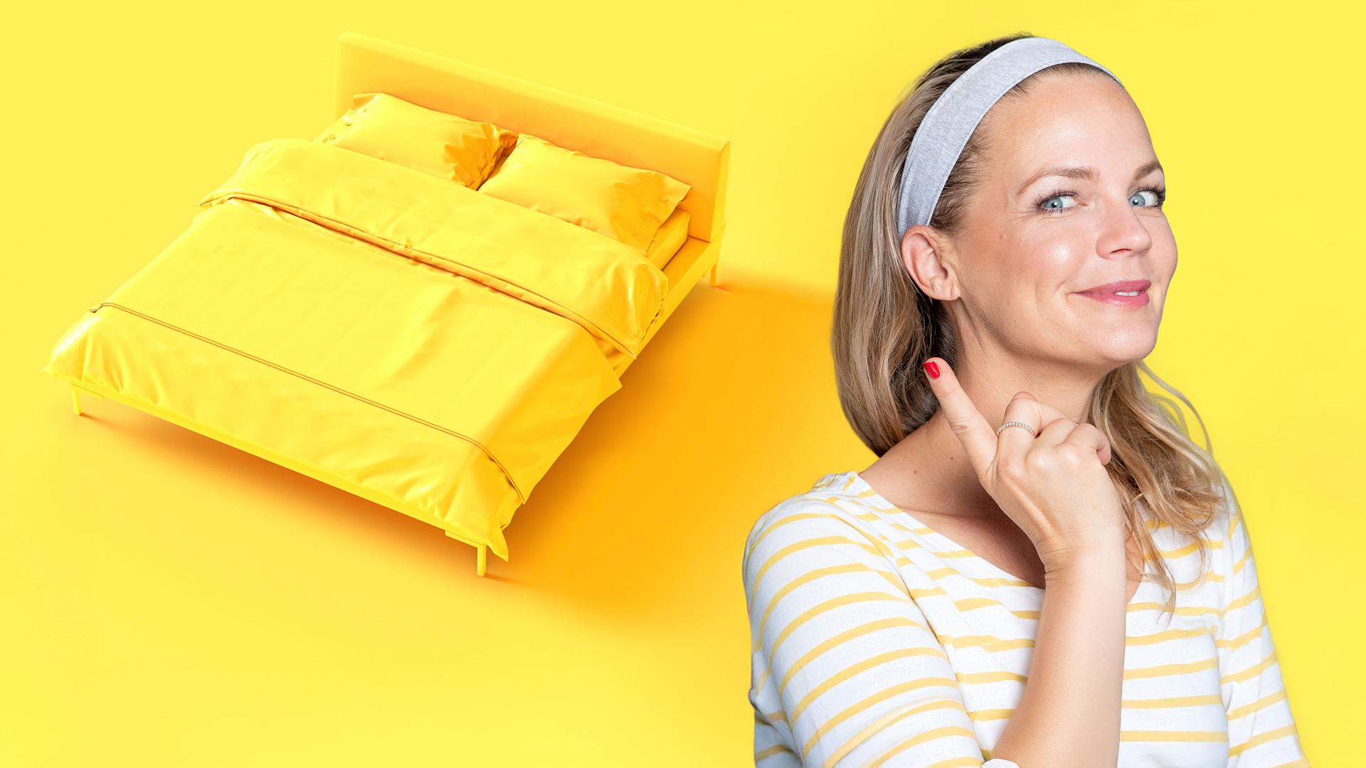 Eva Brenner lächelt, einen Finger erhoben, in die Kamera. Rechts von ihr die gelbe 3D-Animation eines Bettes.