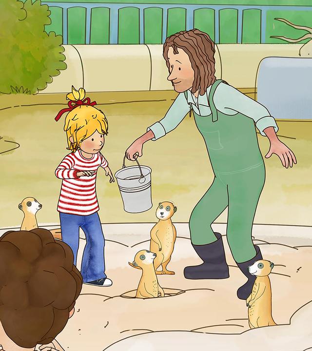 Conni füttert die Erdmännchen im Zoo. Sie steht mit einem Tierpfleger im Gehege und greift nach dem Futter in einem Eimer. Im Vordergrund beobachten Kinder das Spektakel.