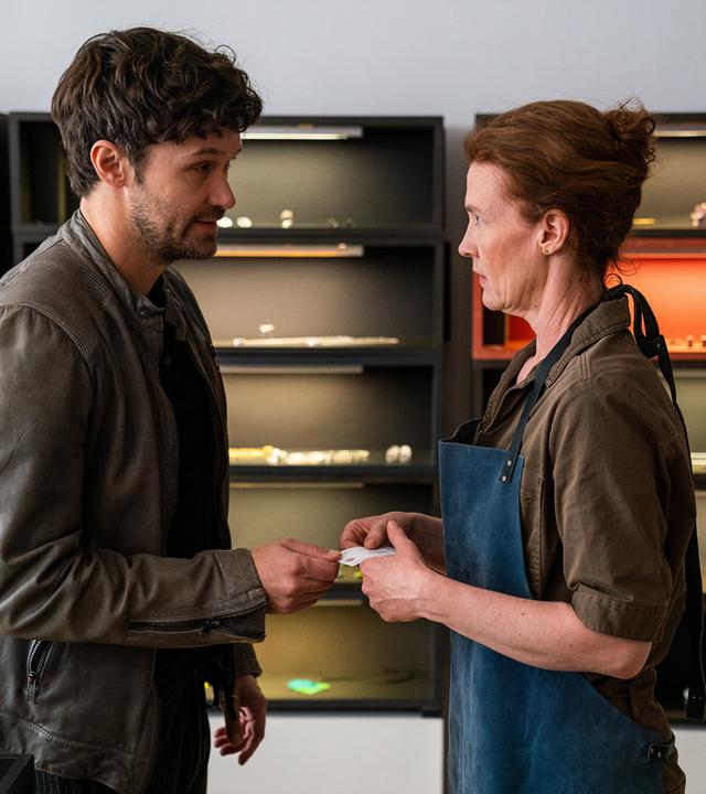 "Letzte Spur Berlin - Memory": Alex von Tal (Aleksandar Radenkovic) und Sarah Volkmann (Julika Jenkins) stehen sich in deren Atelier gegenüber und sehen sich in die Augen. Alex reicht Sarah seine Visitenkarte.