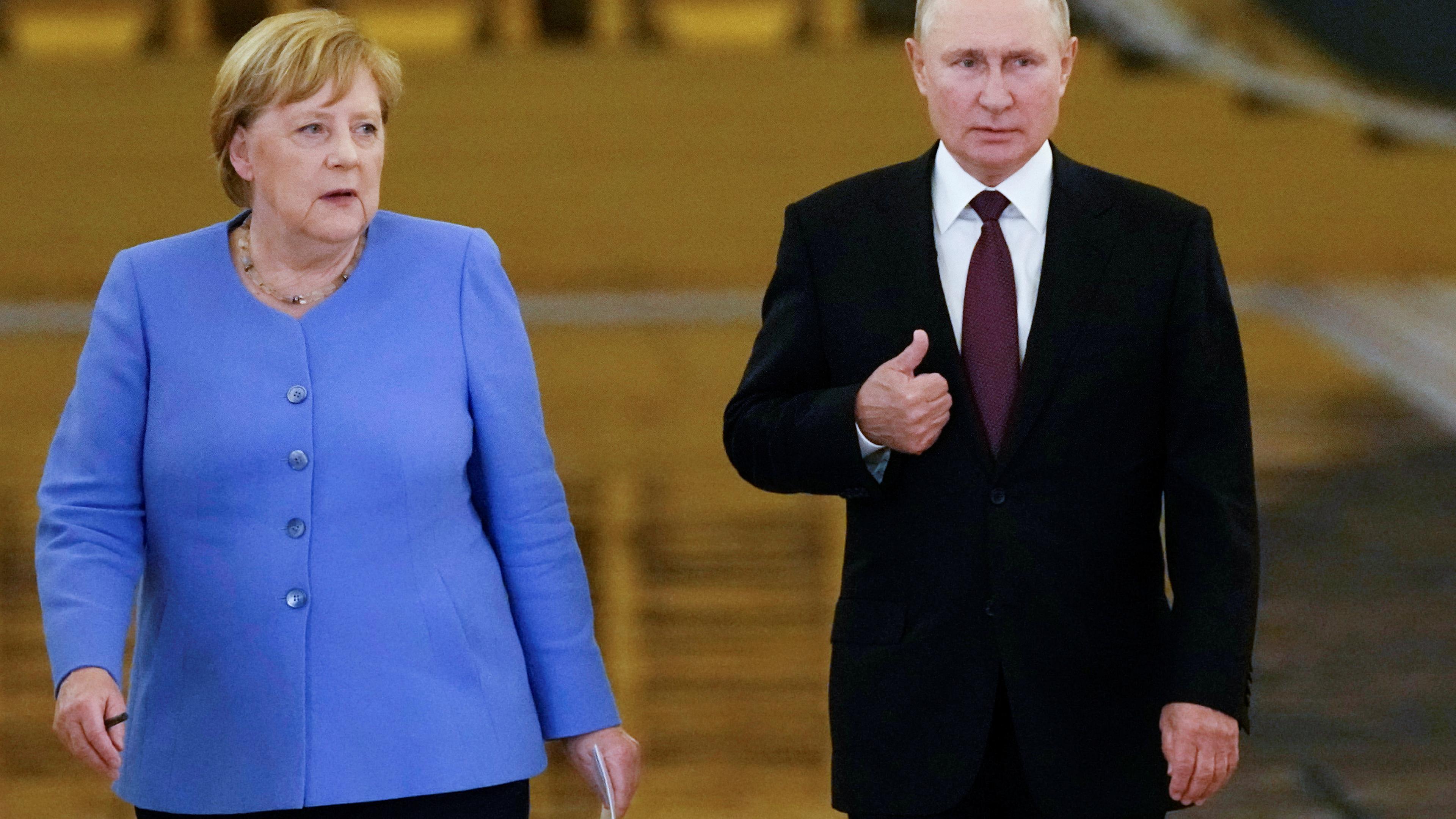 Russian President Wladimir Putin and German Chancellor Angela Merkel enter a hall during a news conference following their talks at the Kremlin in Moscow, Russia