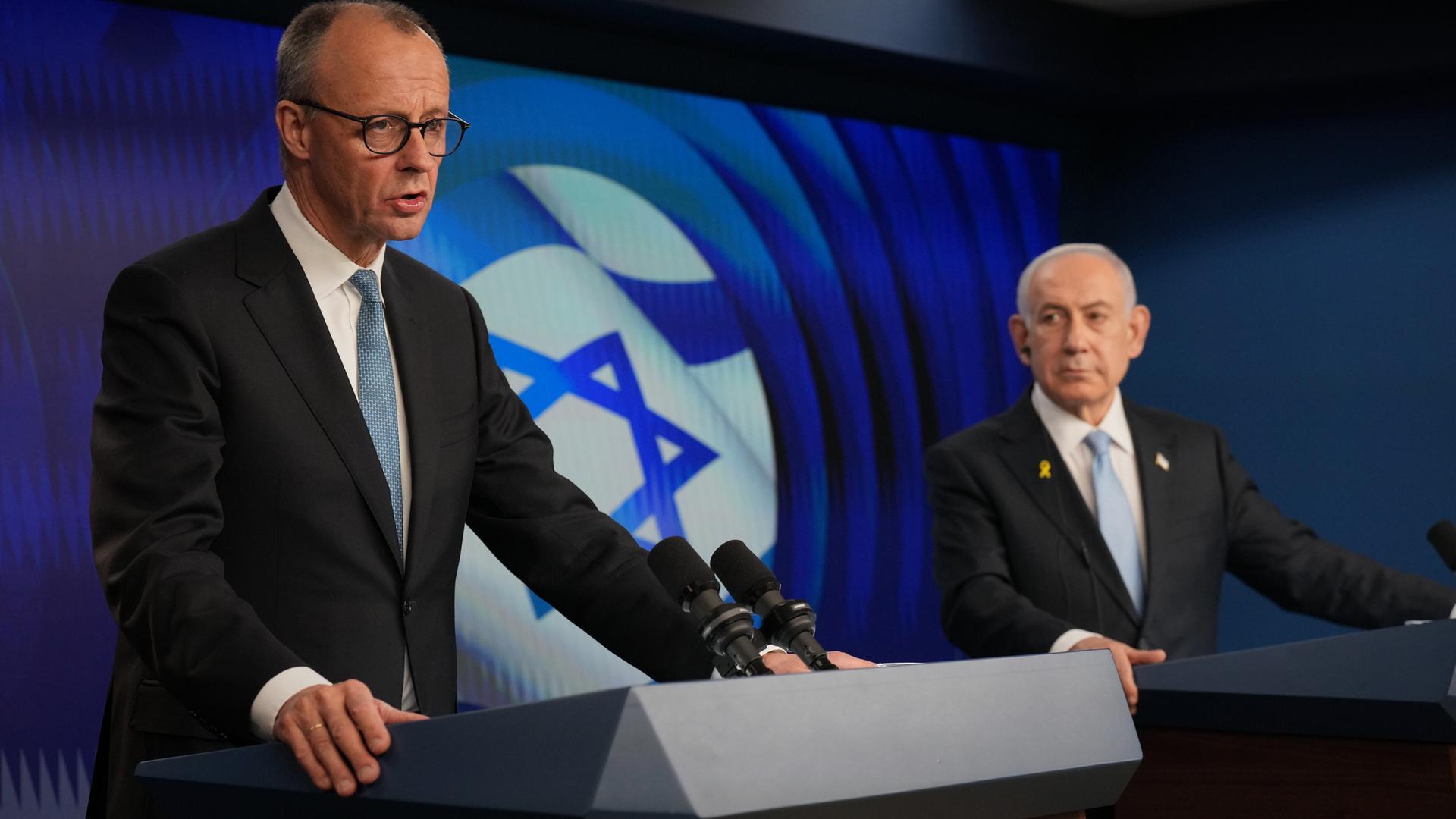 Israeli Prime Minister Benjamin Netanyahu (R) and German Chancellor Friedrich Merz speak to the media during a joint press conference in Jerusalem