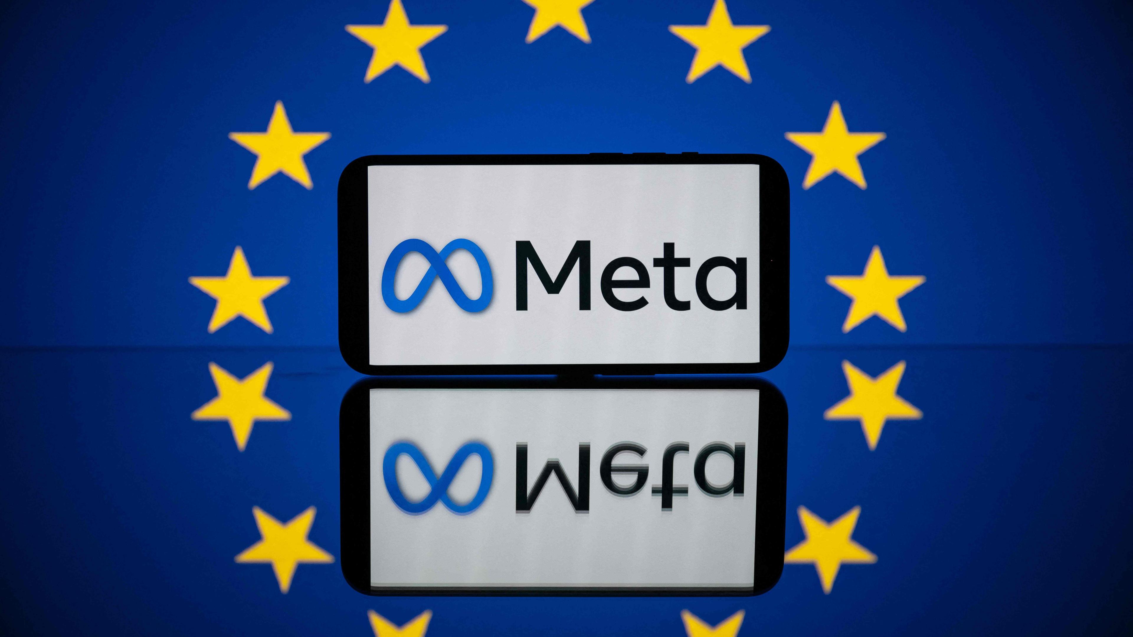Auf einem horizontal liegenden Smartphone das Meta-Logo. Im Hintergrund die Flagge der EU.