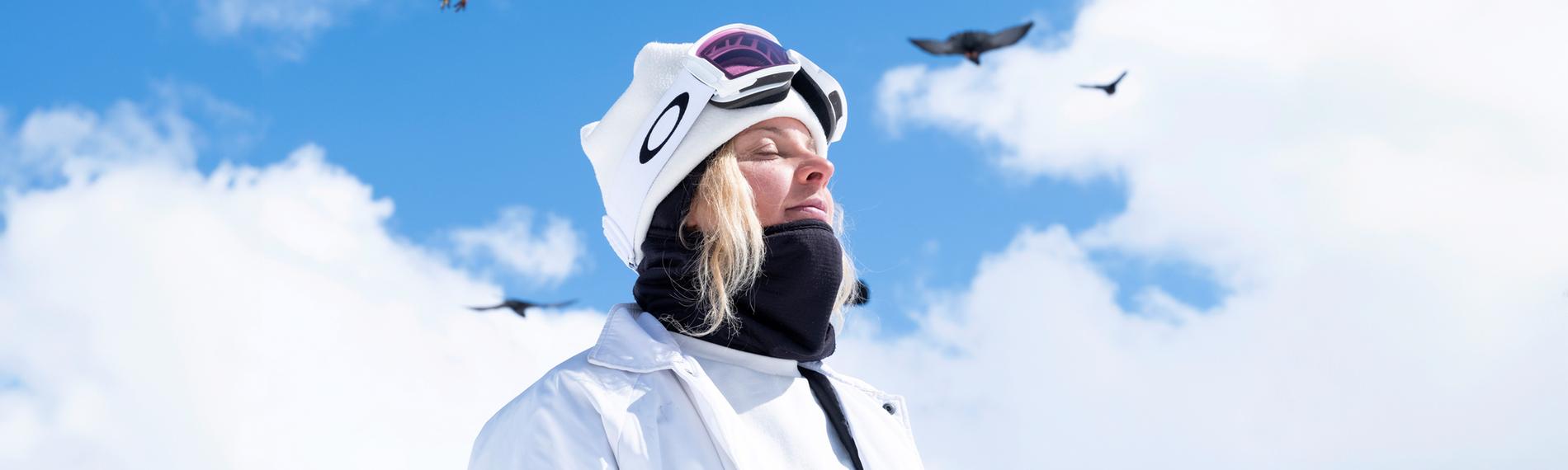 Silvia Mittermüller sitzt vor einem Bergpanorama auf einem sogenannten "Jib", einem Hindernis auf einem Snowboardparcours.