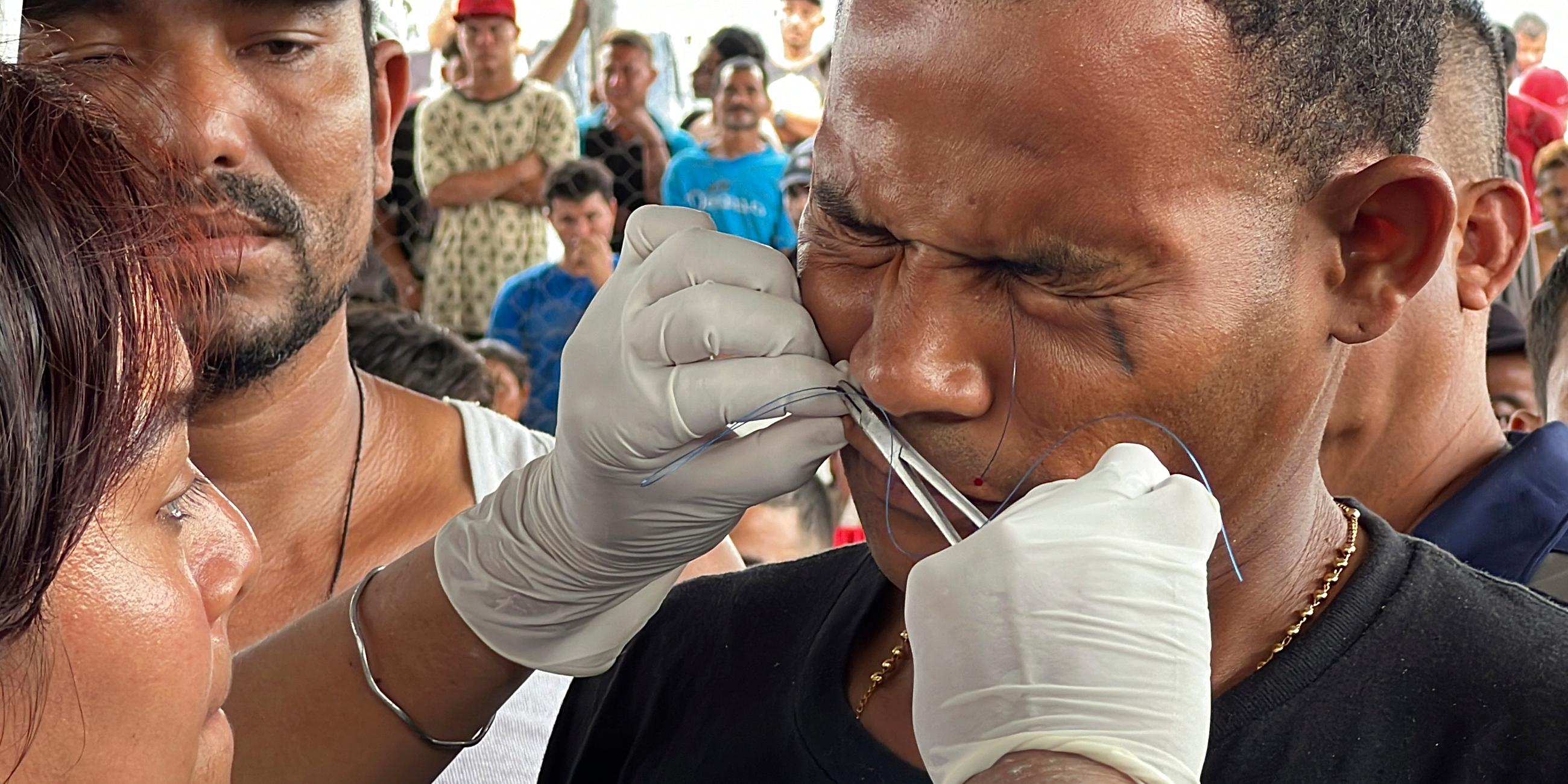Ein Migrant lässt sich in Mexiko die Lippen zunähen - ein Protest.