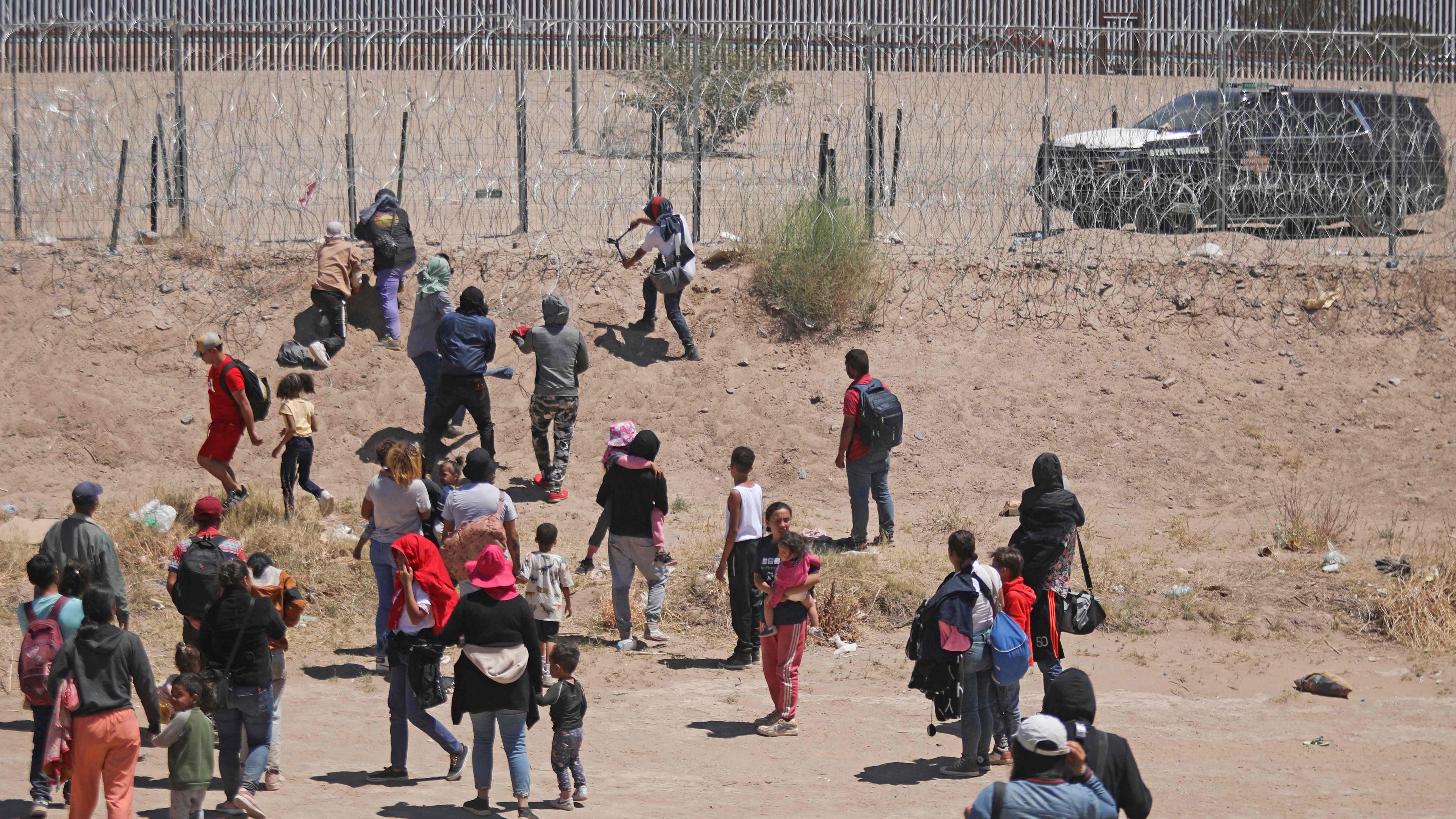 Migranten, die in die Vereinigten Staaten einreisen wollen, versuchen am 13. Mai 2024, einen von der texanischen Nationalgarde errichteten Stachelzaun an der Grenze zu Ciudad Juárez im mexikanischen Bundesstaat Chihuahua zu durchtrennen.