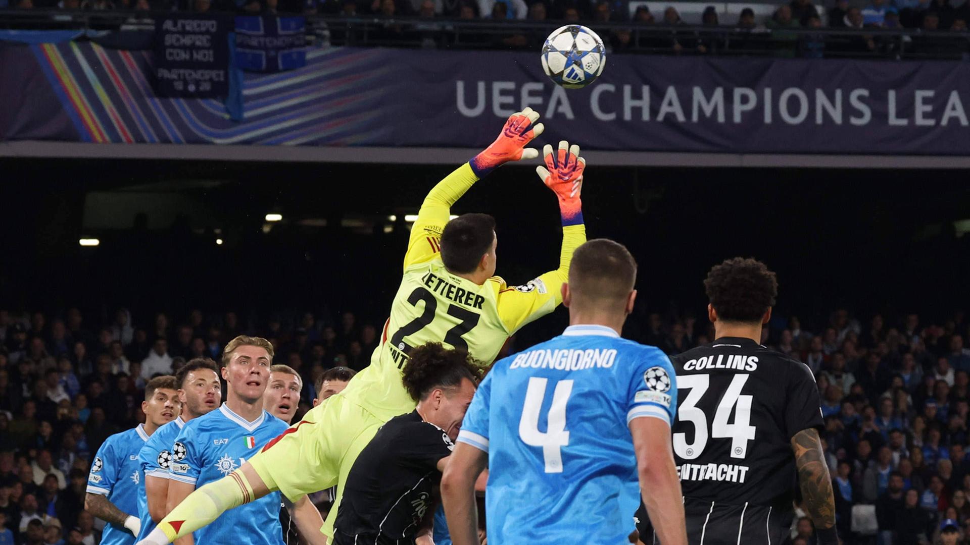 Michael Zetterer springt aus einer Gruppe Spieler heraus nach oben und blockt mit den Händen den heranfliegenden Ball ab.