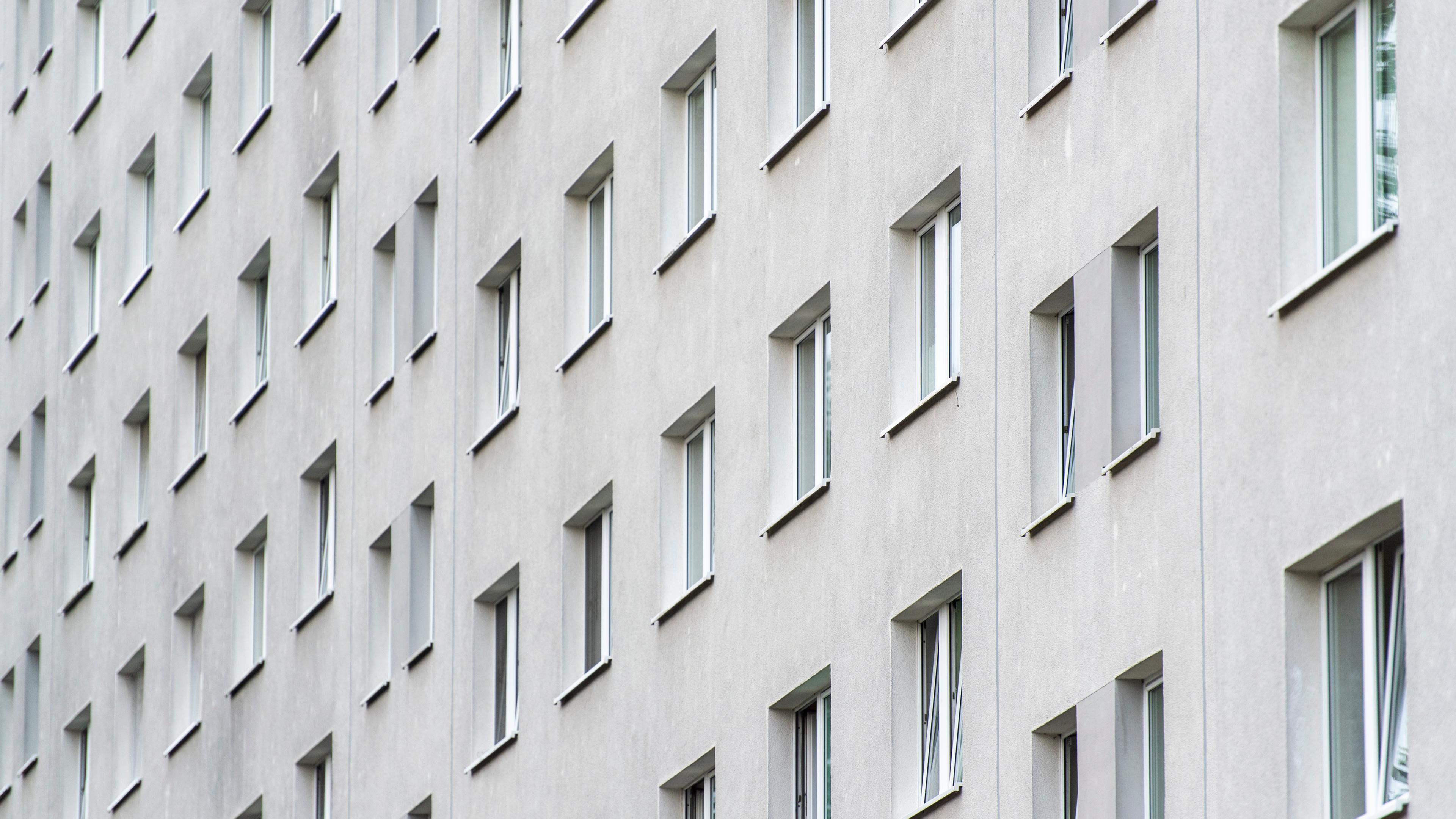 Berlin: Blick auf eine graue Hausfassade mit vielen Fenstern.