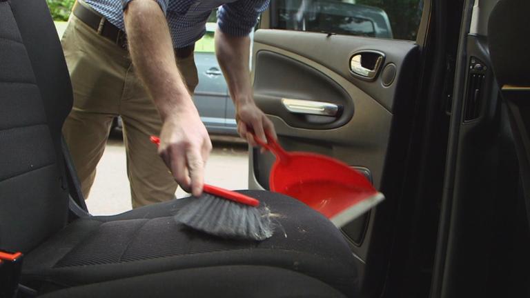 Mann reinigt Mietwagen