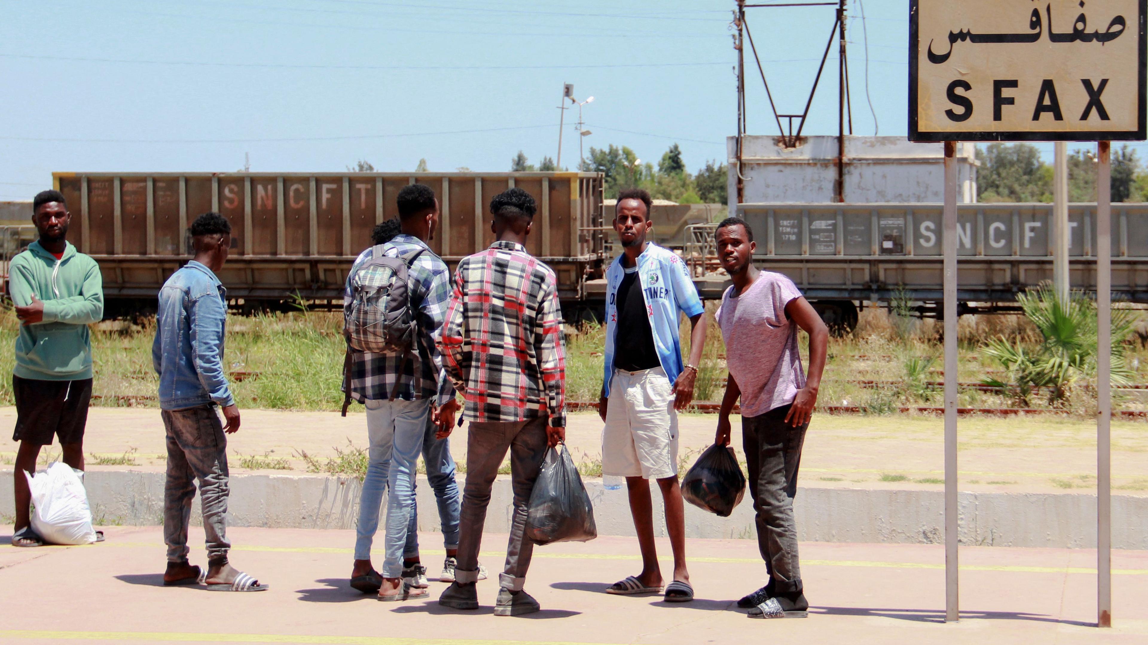Afrikanische Migranten warten am 5. Juli 2023 am Bahnhof auf einen Zug, als sie nach Tunis fliehen, inmitten von Unruhen in Sfax, nachdem am 3. Juli ein tunesischer Mann bei einer Auseinandersetzung mit Migranten erstochen wurde. 