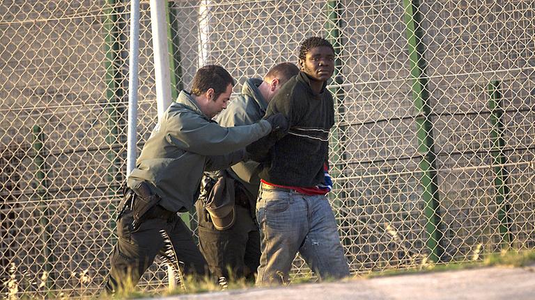 Migrant wird von spanischen Polizisten festgenommen