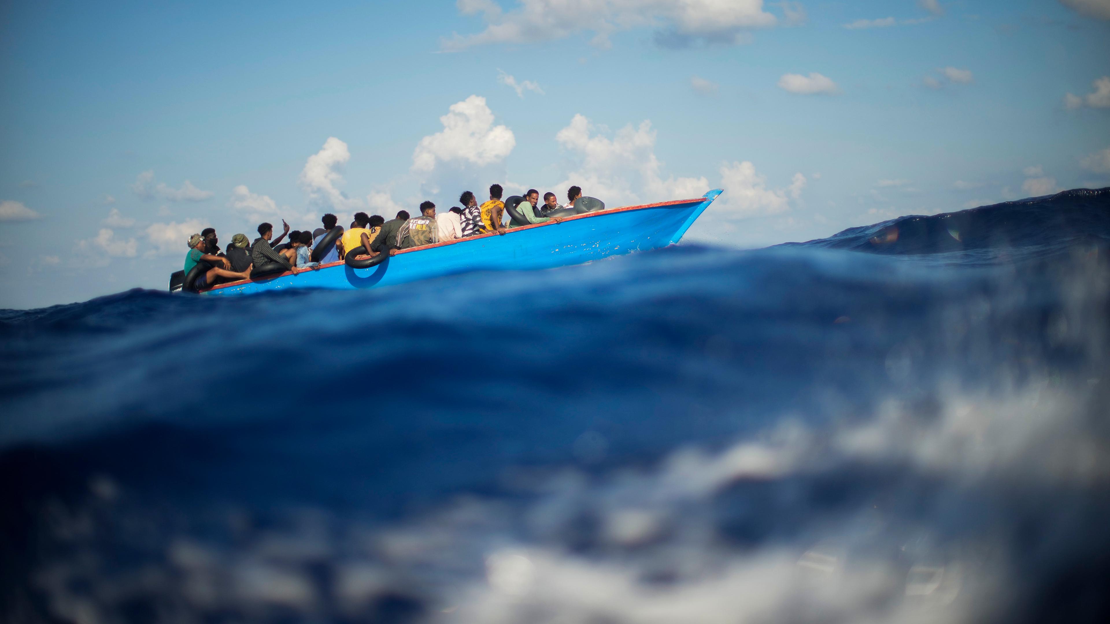 Italien: Migranten sitzen in einem Holzboot südlich der italienischen Insel Lampedusa auf dem Mittelmeer.
