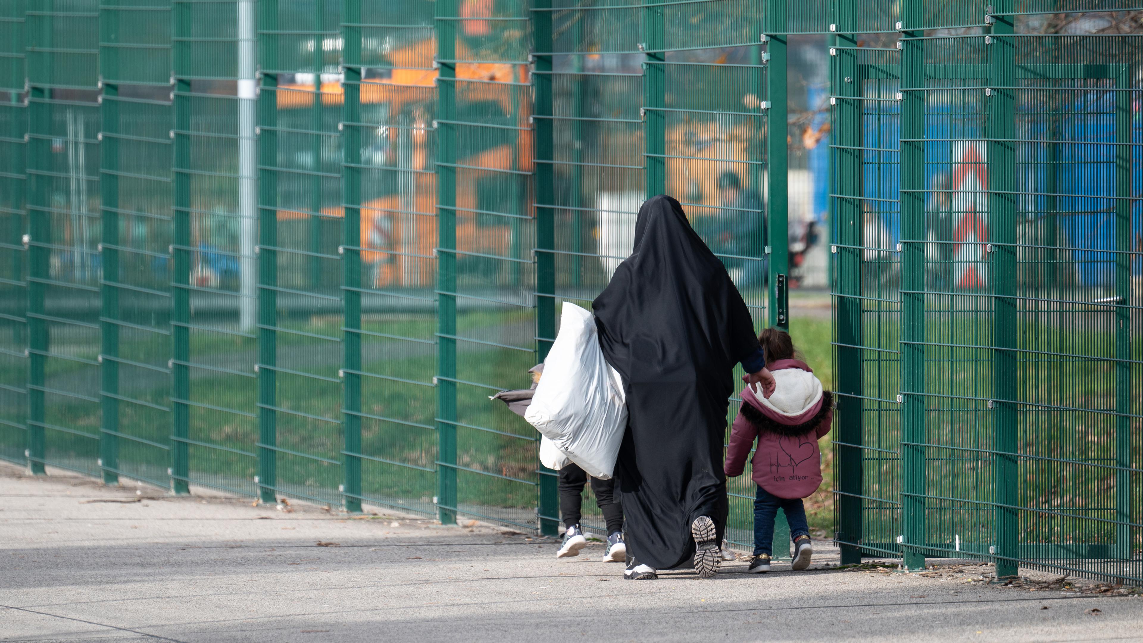  Eine Frau geht mit ihren Kinder über das Außengelände der Erstaufnahmeeinrichtung (HEAE) in Gießen am 22.11.2023.