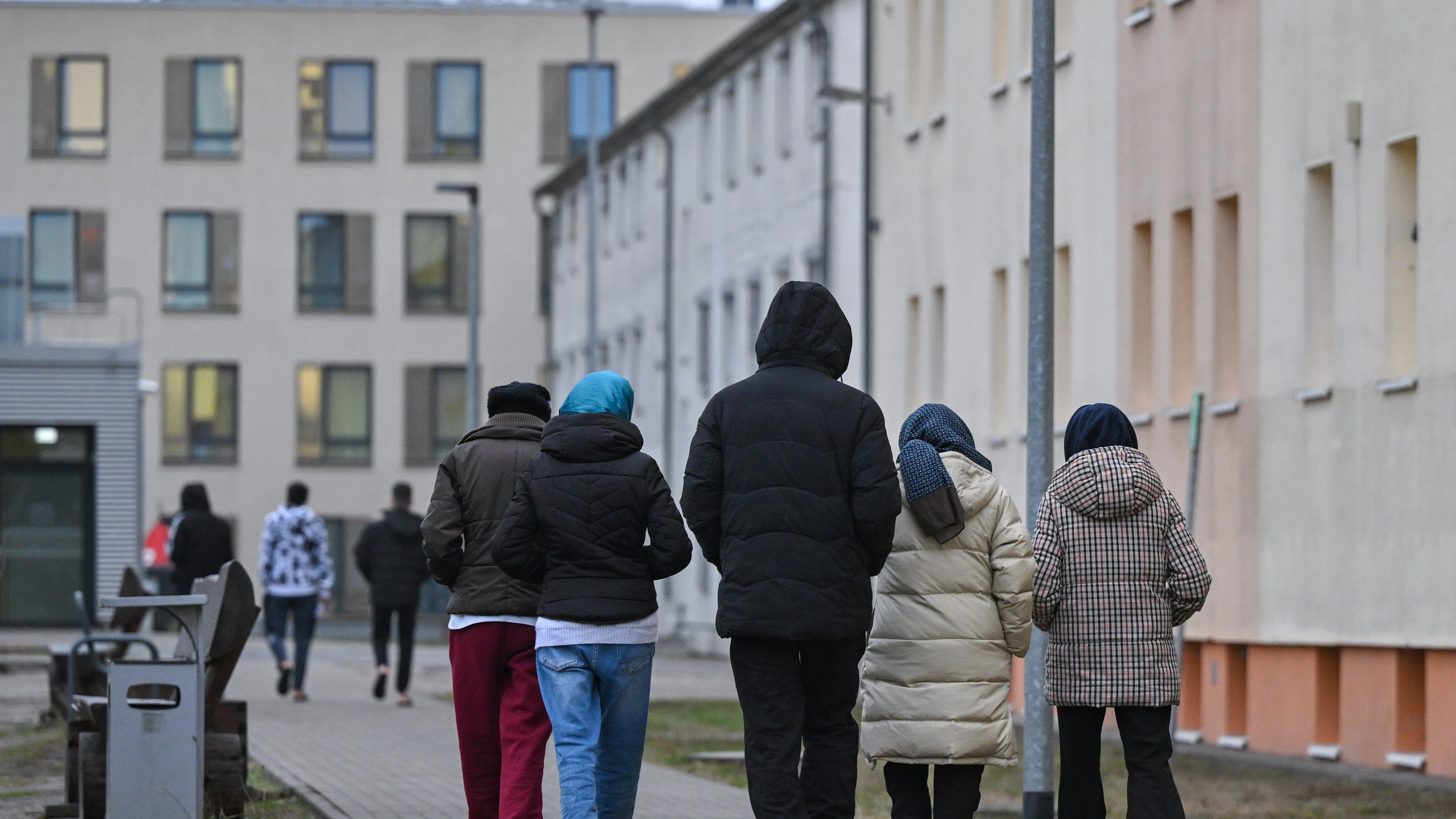 Brandenburg, Eisenhüttenstadt: Migranten gehen über das Gelände der Zentralen Erstaufnahmeeinrichtung für Asylbewerber (ZABH) des Landes Brandenburg in Eisenhüttenstadt.