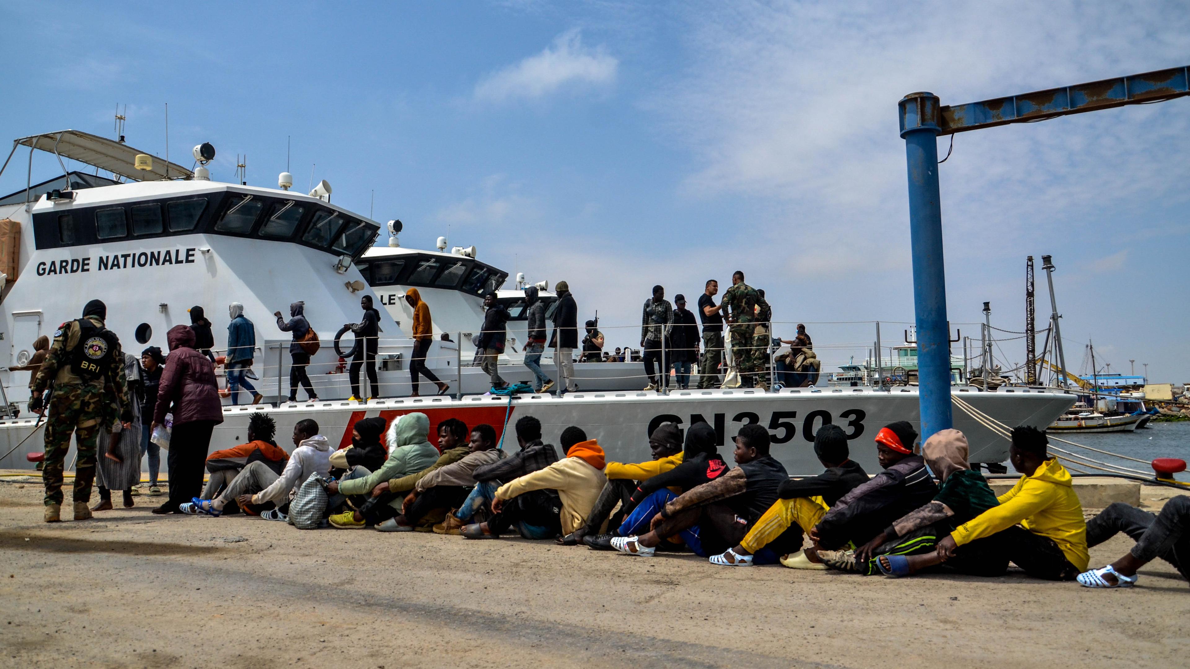 Tunesien, Sfax: Subsaharische Migranten, die von der tunesischen Marine-Nationalgarde im Mittelmeer abgefangen wurden, warten im Hafen.