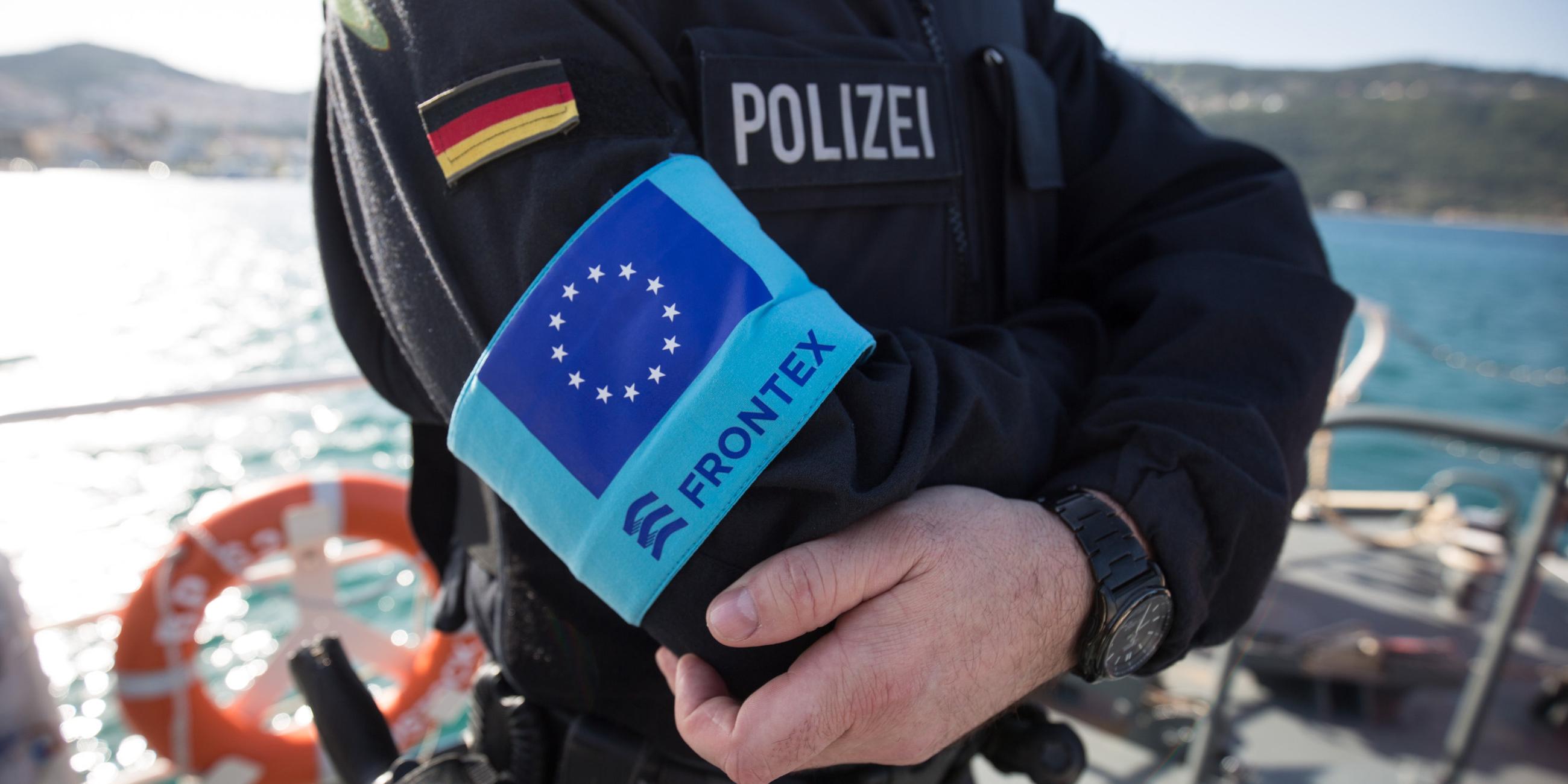 Polizist auf Schiff mit Frontex-Logo auf der Uniform.