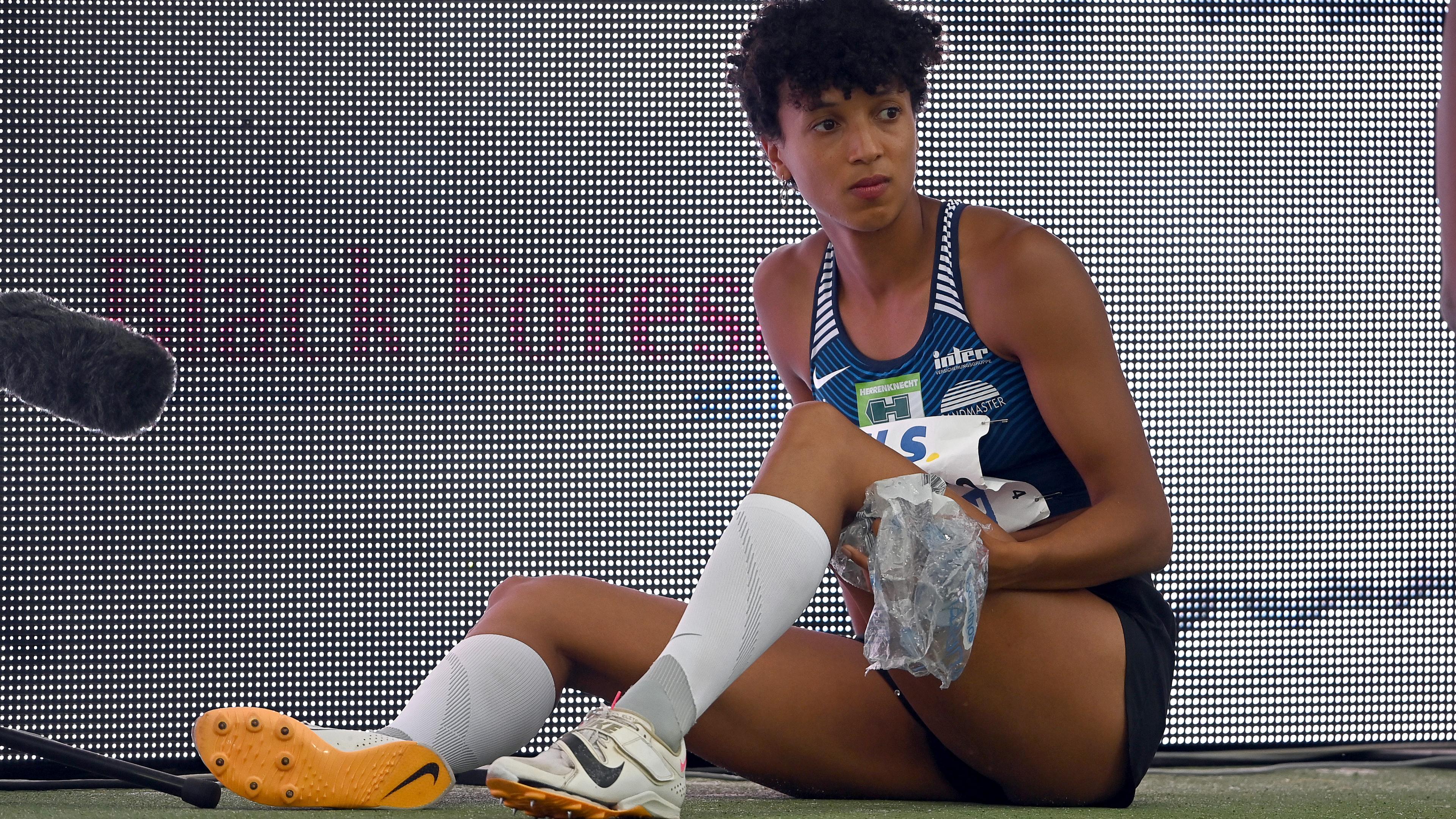 Leichtathletik, Deutsche Meisterschaft: Weitspringerin Malaika Mihambo sitzt auf dem Boden und hält sich Eisbeutel an den Oberschenkel.
