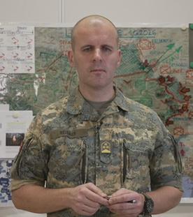 Oberst Markus Reisner vor einer Karte der Ukraine bei der die Front eingezeichnet ist