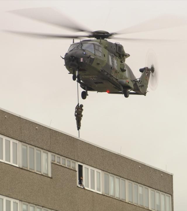 Ein Militärhubschrauber seilt Soldaten ab
