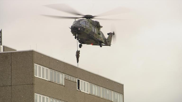 Ein Militärhubschrauber seilt Soldaten ab