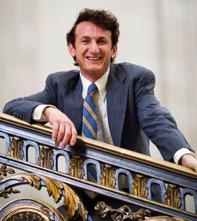 "Milk": Harvey Milk (Sean Penn) und Bürgermeister Moscone (Victor Garber) stehen gemeinsam auf einer Bühne vor klatschendem Publikum. Sie heben ihre Hände in die Luft und lächeln.