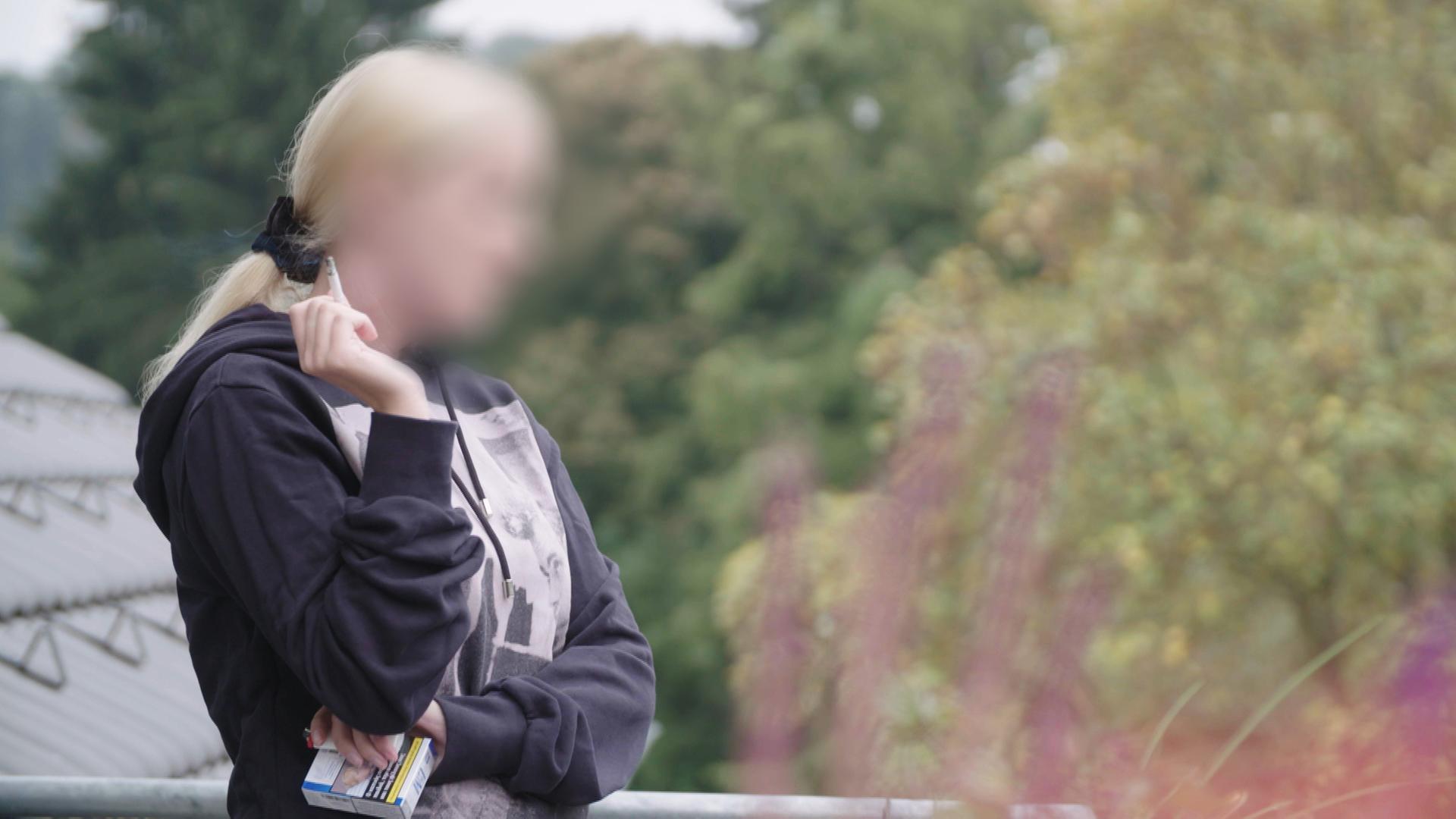 "Milliardengeschäft Porno - Gefahr aus dem Internet": Eine unkenntlichgemachte Frau mit Zigarette in der Hand schaut ins Grüne.