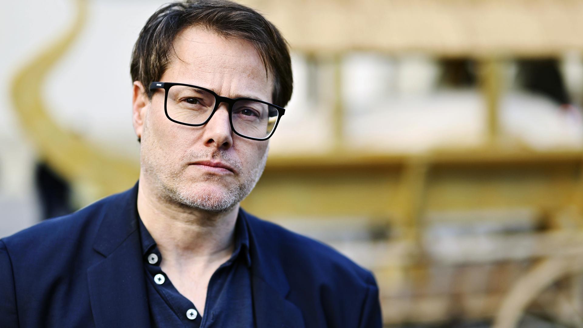 Ein Mann trägt eine Brille.