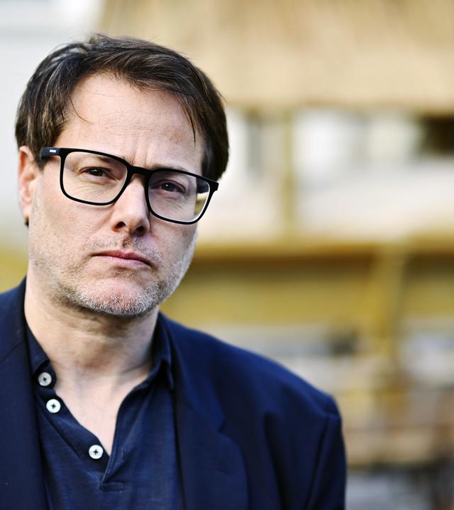 Ein Mann trägt eine Brille.