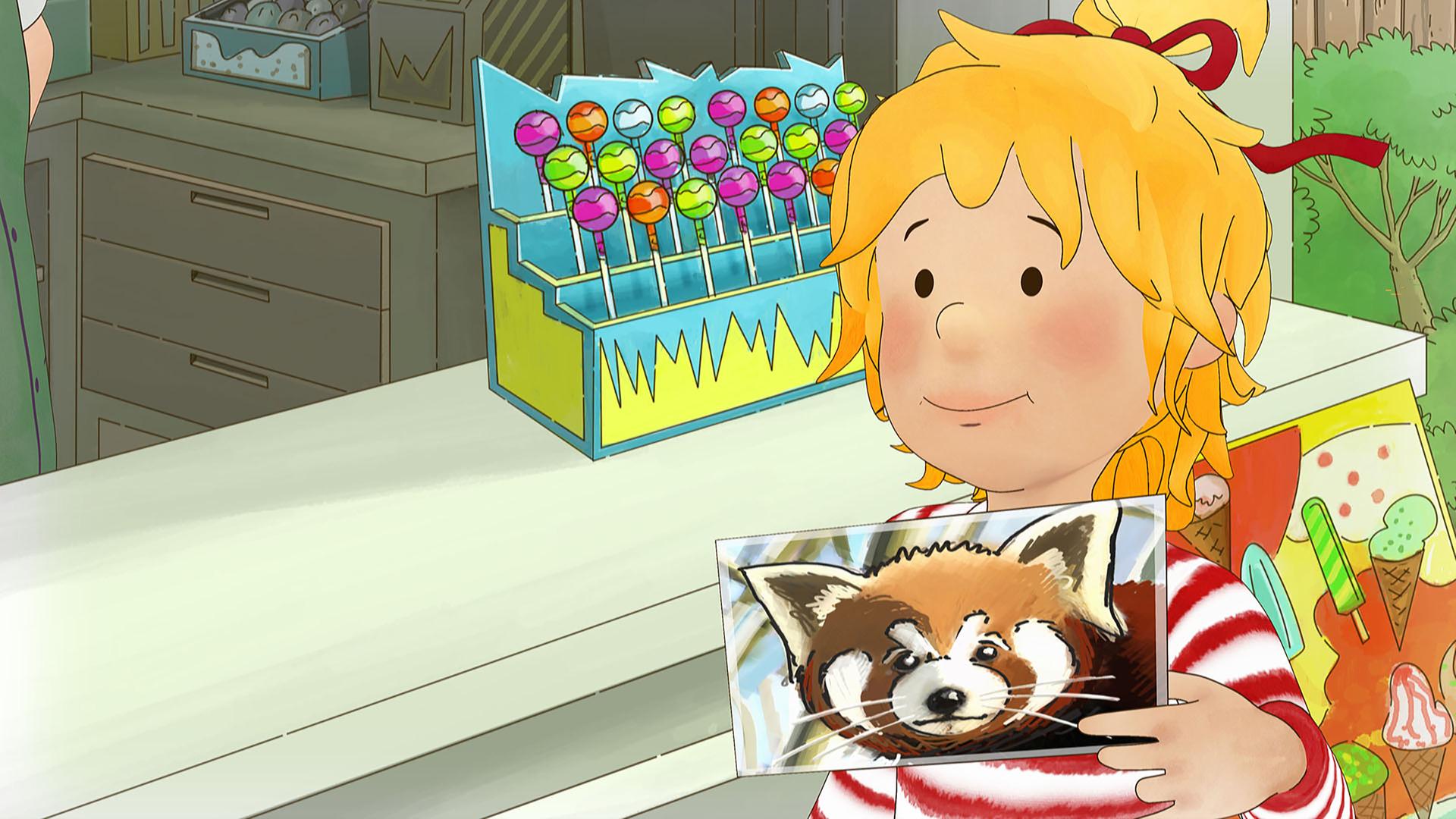 Conni steht im Zoo an der Kasse. Sie hält eine Postkarte mit einem roten Panda in der Hand.