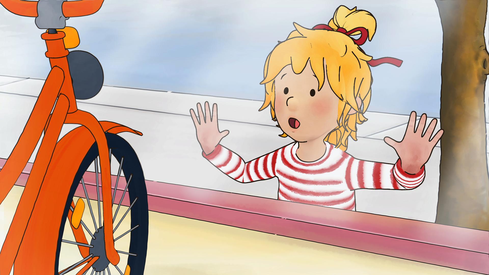 Conni sieht sich ein Fahrrad im Schaufenster an.