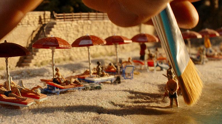 Pinselarbeiten an einem Strand in der Miniaturwelt