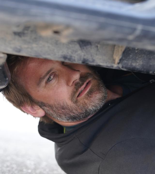 "Mirage - Gefährliche Lügen": Gabriel (Clive Standen) hat sich unter einem Auto versteckt.