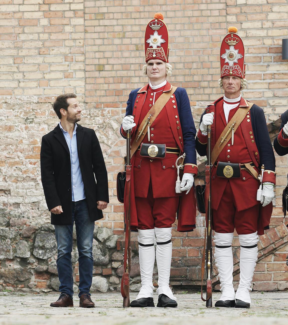 Mirko Drotschmann steht neben riesen großen Darstellern in Gardeuniform.