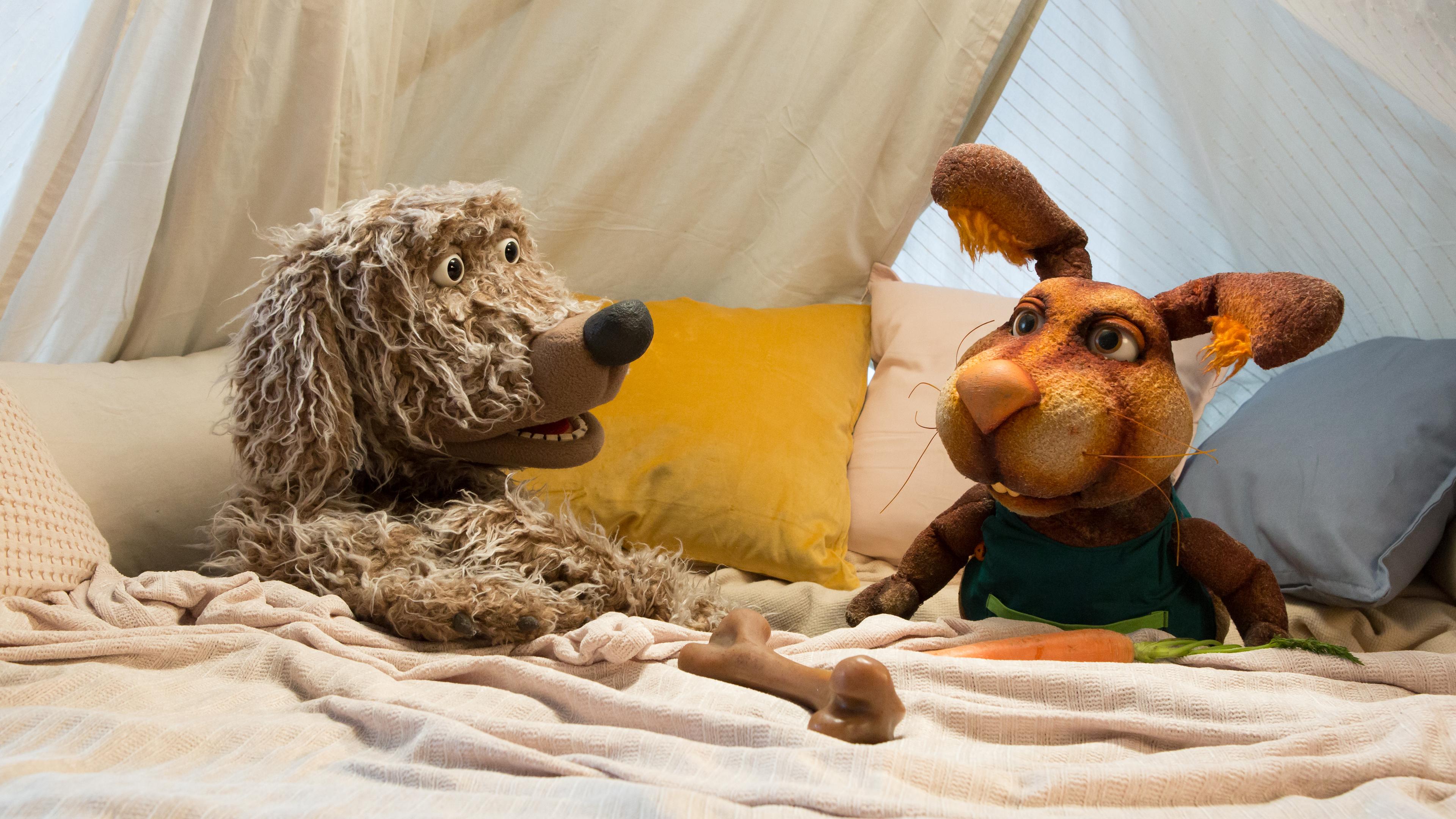 Buffo und Otto hocken in der Kuschelecke und schauen sich fragend an. Vor Buffo liegt ein Knochen, vor Otto eine Möhre.