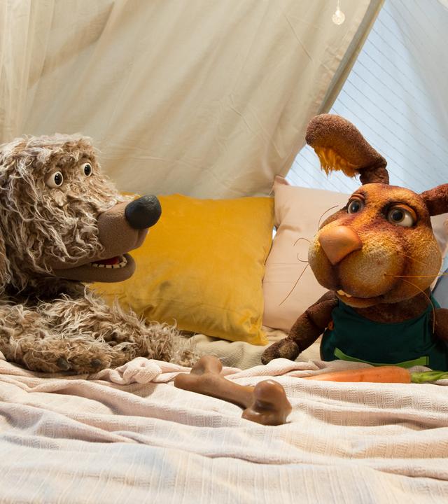 Buffo und Otto hocken in der Kuschelecke und schauen sich fragend an. Vor Buffo liegt ein Knochen, vor Otto eine Möhre.