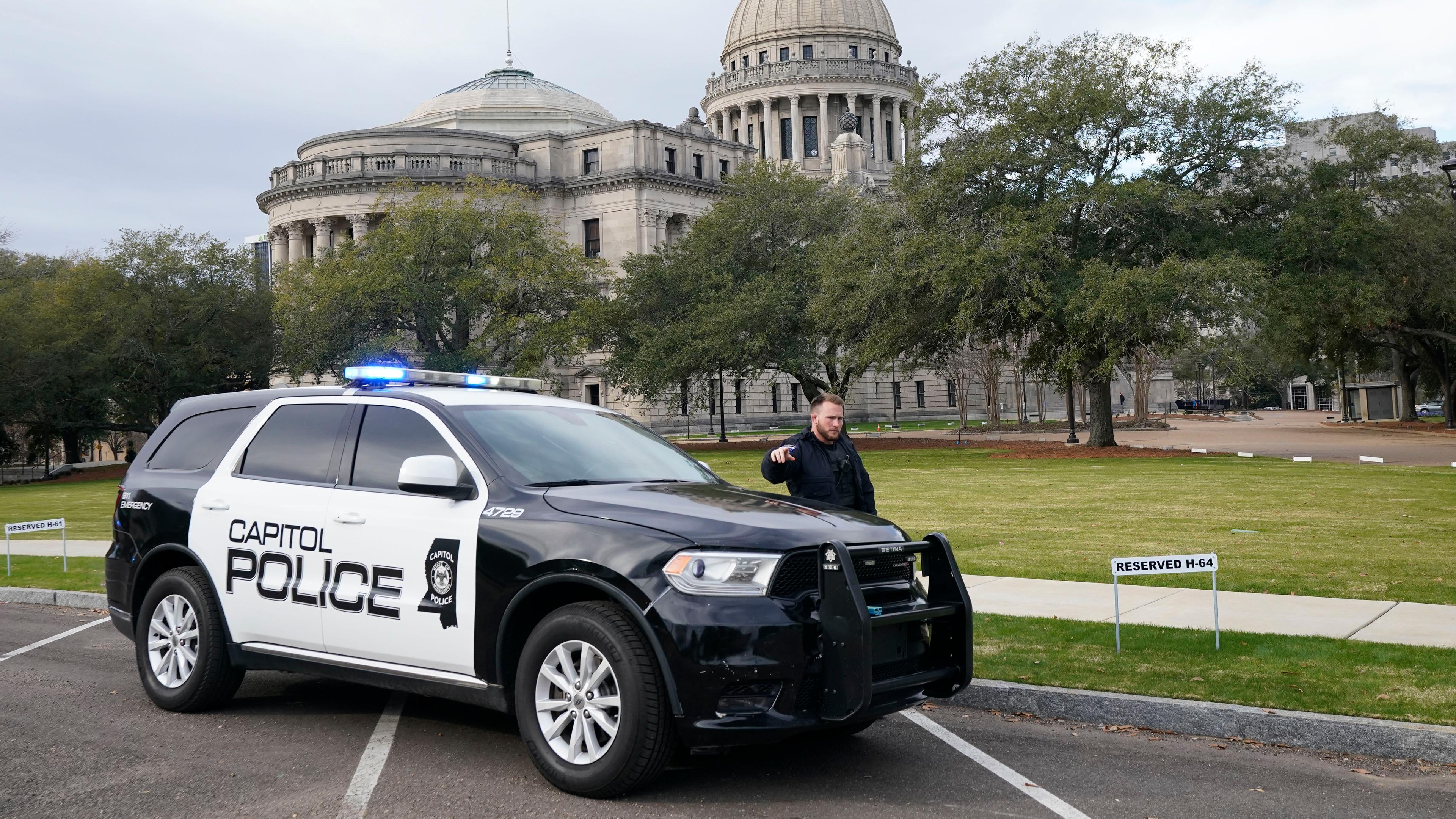 Ein Beamter der Capitol Police warnt Passanten vor dem Mississippi State Capitol in Jackson vor einer Bombendrohung.