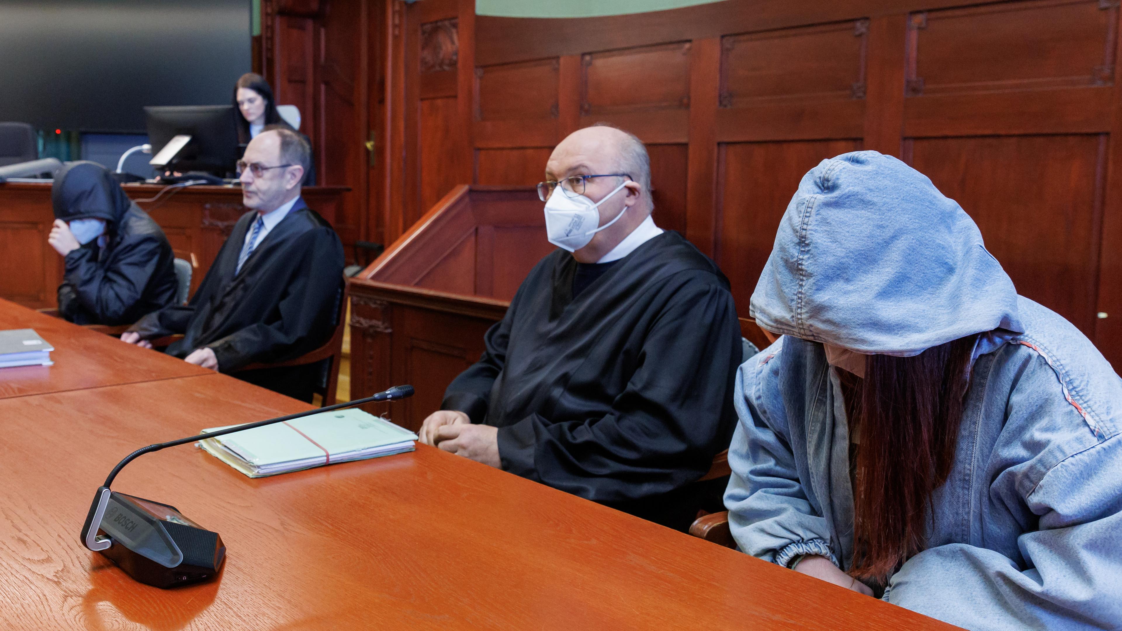 Bayern, Bayreuth: Die beiden Angeklagten, der 19-jährige Mann (l) und die 17-jährige Frau (r), sitzen neben ihren Rechtsanwälten.