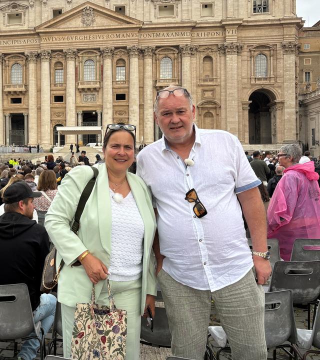 Sonja und Waldi stehen vor dem Pertersdom im Vatikan und lächeln in die Kamera.