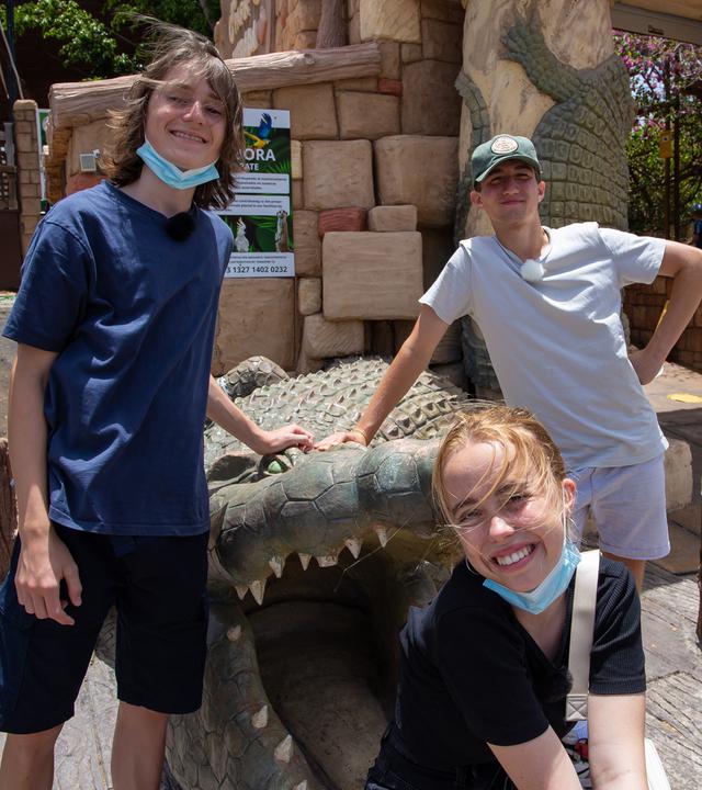 Leo, Lia und Adis stehen vor dem Eingang zu einem Tierpark