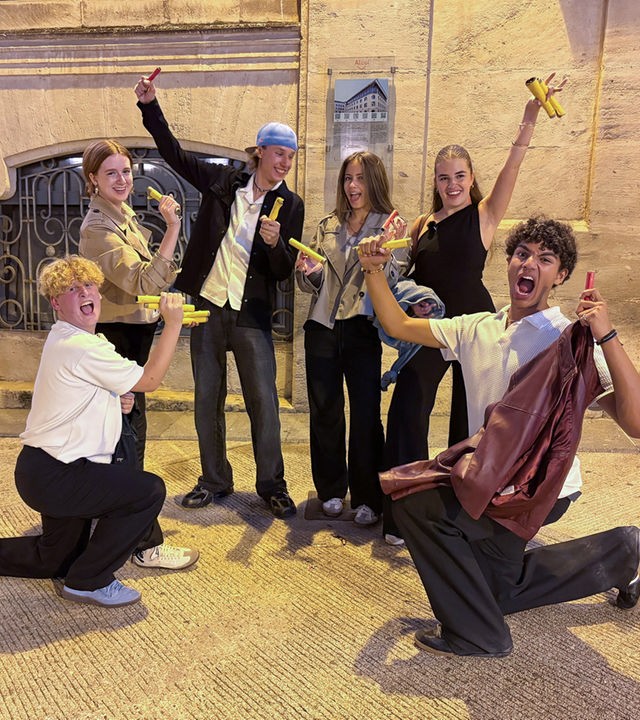 v.l.n.r. Rufus, Marie, Jan, Lina-Marie, Lenja und Adrian stehen in einem Halbkreis und machen jubelnde Gesten. Jeder hat mehrere, gelbe Kunststoffröhren in der Hand. Rufus und Adrian knien, der Rest steht.